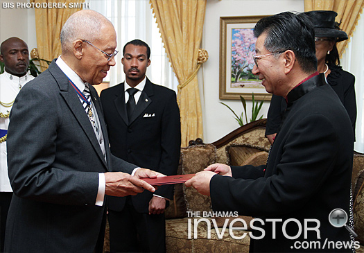 Sir Arthur Foulkes (left), accepts Letters of Credence presented by Ambassador Yuan Guisen